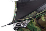 Close-up of a camouflage camping tarp shelter with a black mesh fly and reflective silver inner liner.