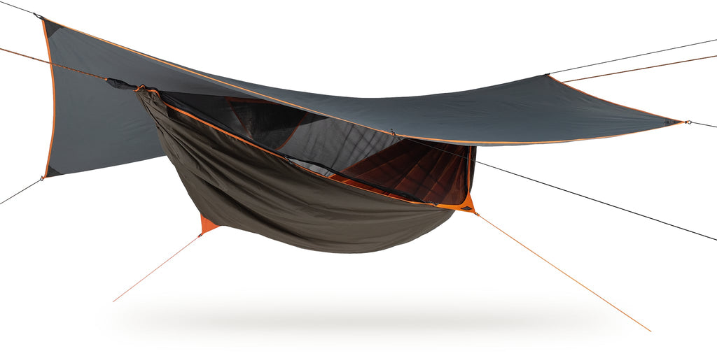 Photo of a four season survivorman hammock set up against a white background.  The hammoick is brown and grey with orange trim and interior.