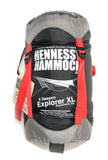 Photo of a black, grey and red four season Explorer stuff sack with white printing.  Printed on the stuff sack is the Hennessy Hammock logo, an illustation of the hammock, the model name, and other technical information.
