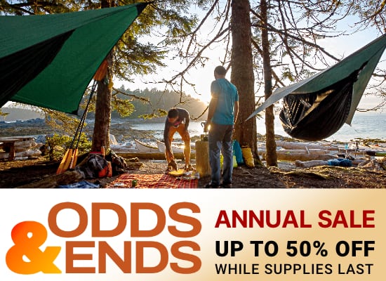 Odds & Ends Sale banner, showing two people setting up camp by the shoreline, with kayaking equipment near the hammocks, close to sunset.